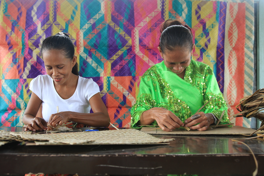 Women of the Bunawan Mat Weavers’ Association work with their hands using Romblon material to produce handicraft items.