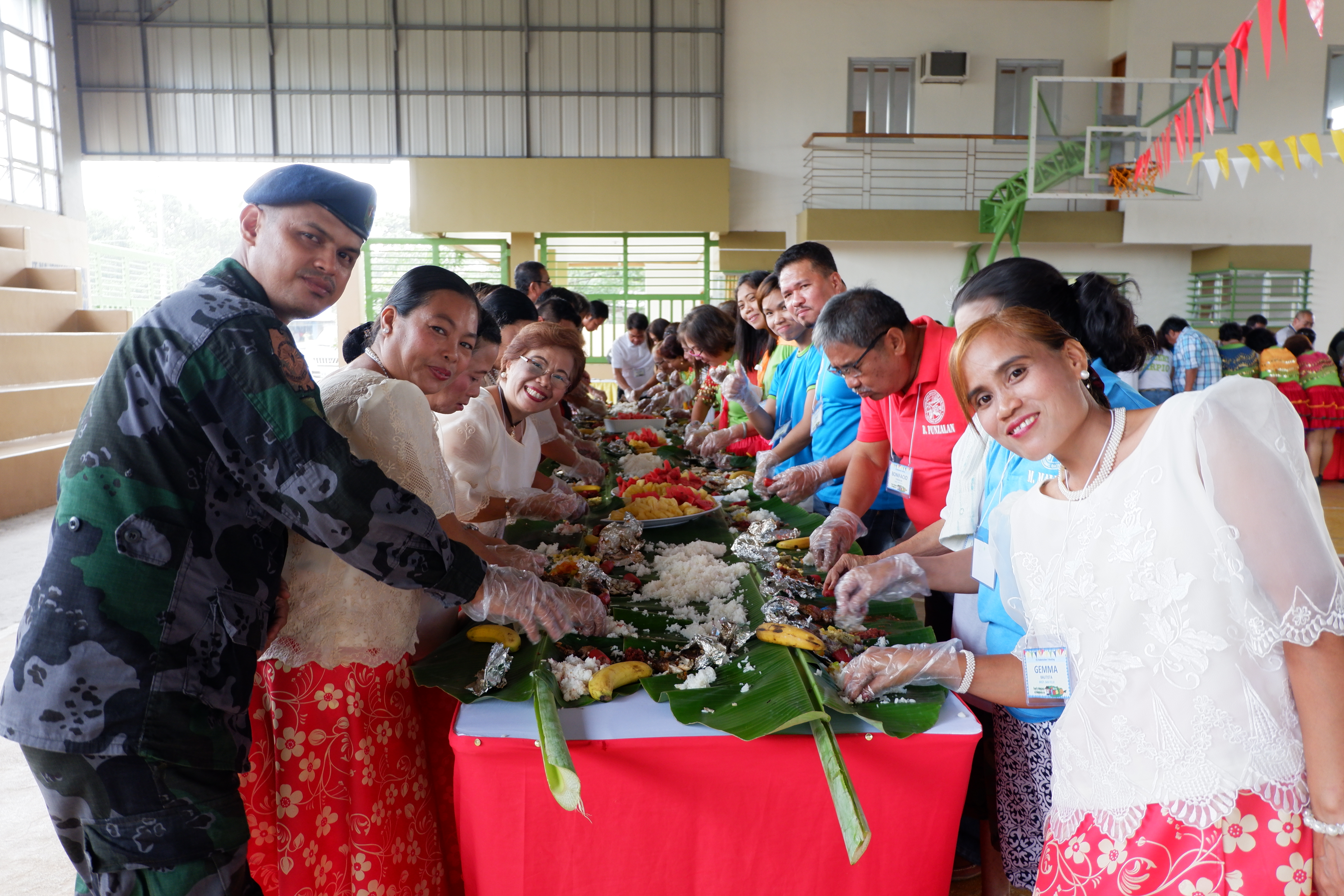 APRI team members and stakeholders eat together, boodle fight style. 