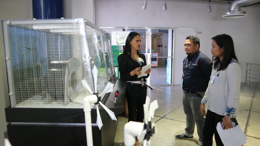 Cleanergy Youth Ambassador Kevin Basset gladly discusses the wind turbine display to APRI team members.