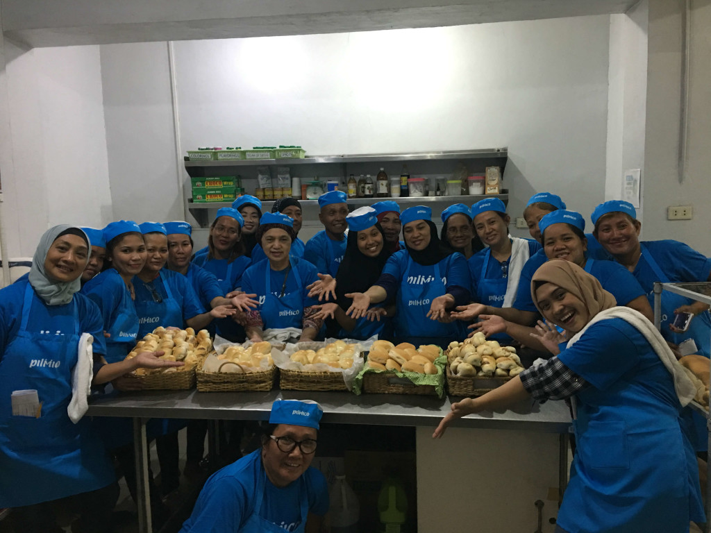 Beneficiaries of "PAGKAIN Biyaya ng Pagbabago Bakery Livelihood Program" proudly showing the bread and pastries they baked 