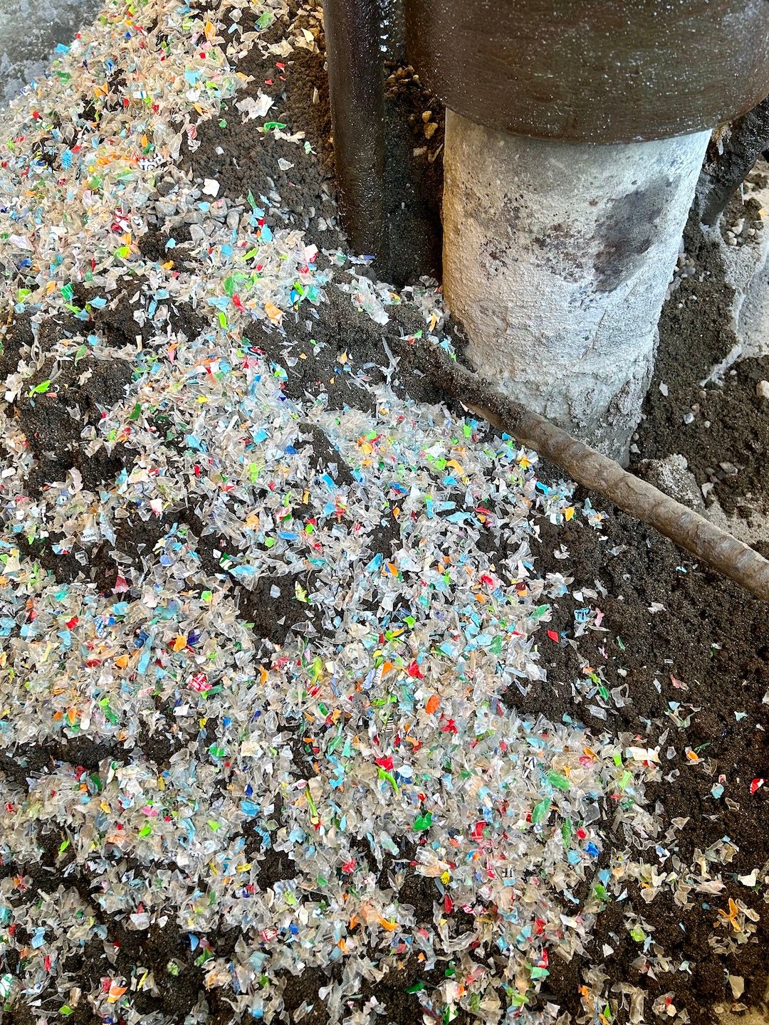 Shredded plastic, collected from the community in exchange for rice, is mixed with coal ash and cement
