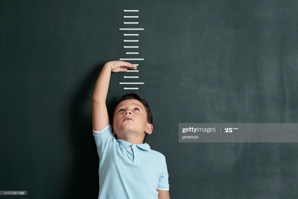 Child measuring his height on wall. He is growing up so fast. : Stock Photo